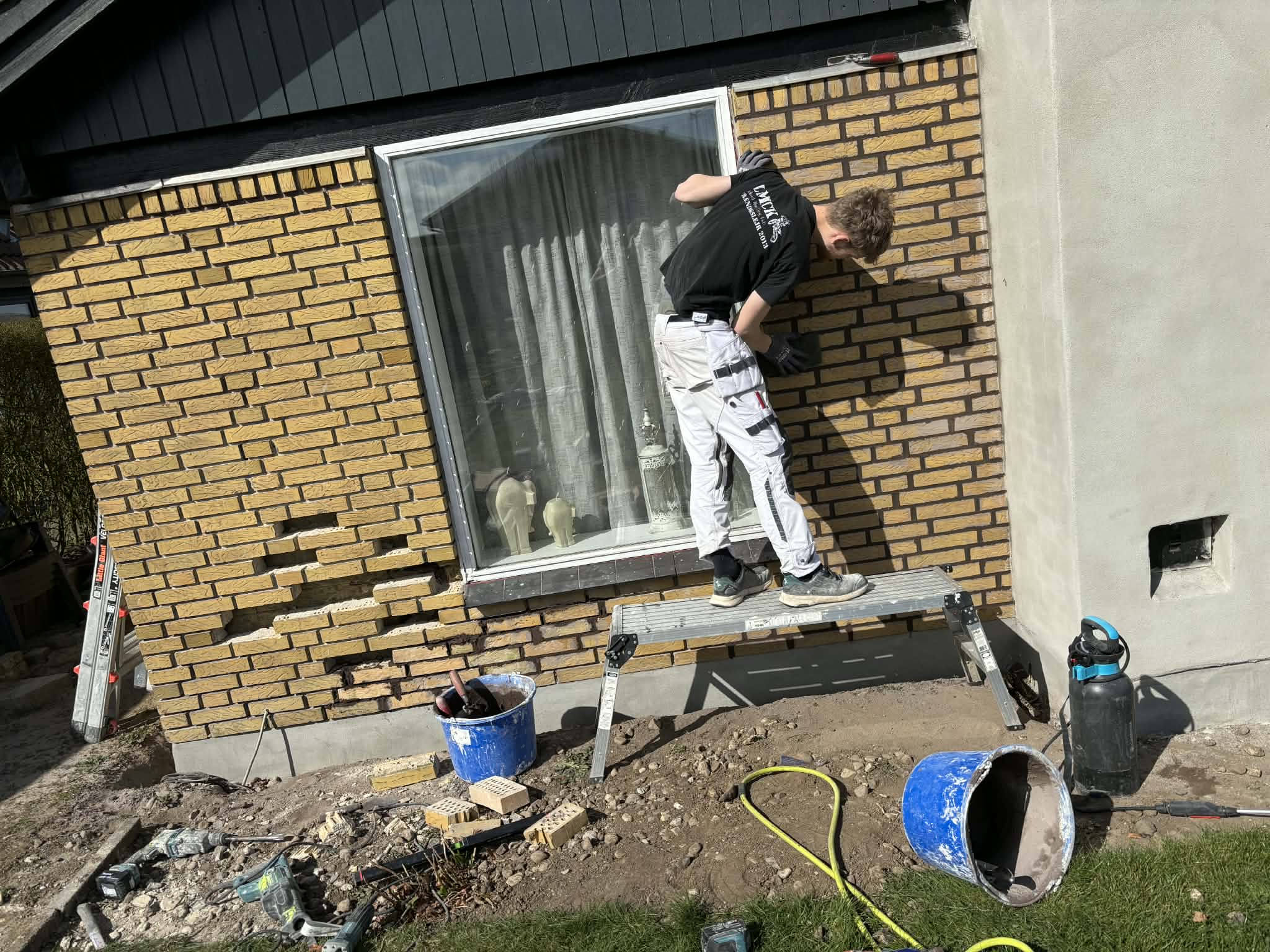Håndværker i gang med facadearbejde